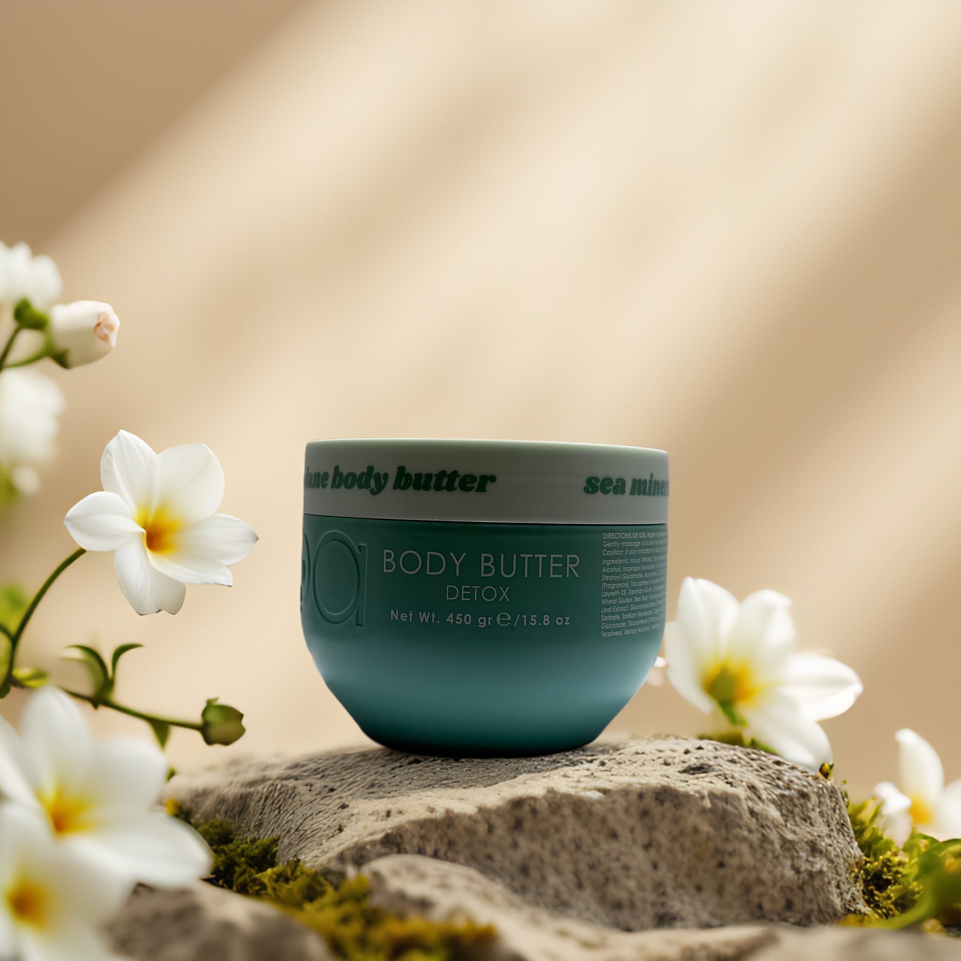 Deep Hydration & Detox Sea Mineral Body Butter by Circa Beauty on a stone surface with flowers.