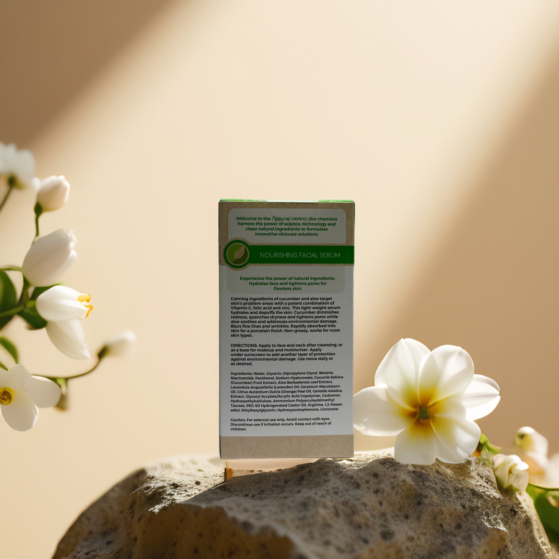 Cucumber Aloe Nourishing Facial Serum box with floral background on stone, highlighting natural ingredients for skin care.
