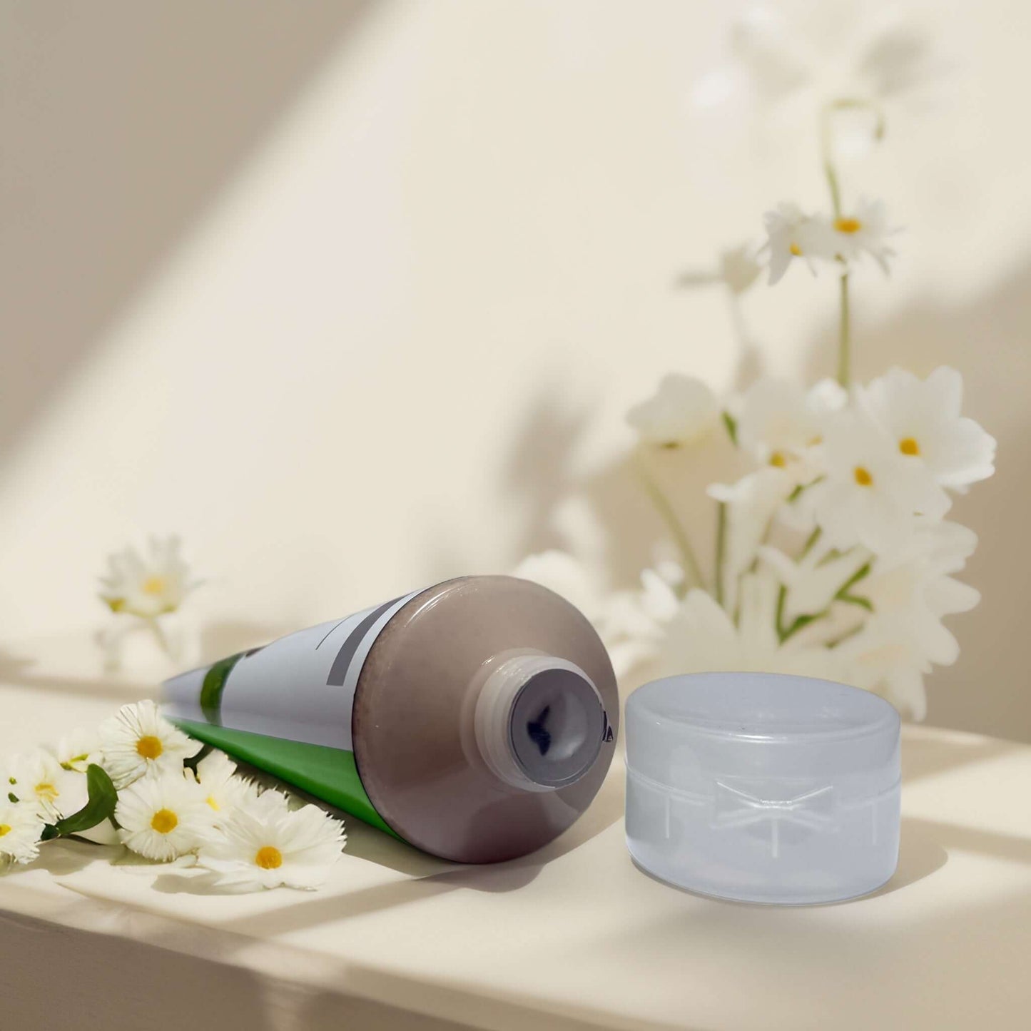 Energizing Caffeine & Mint facial scrub tube with flowers.