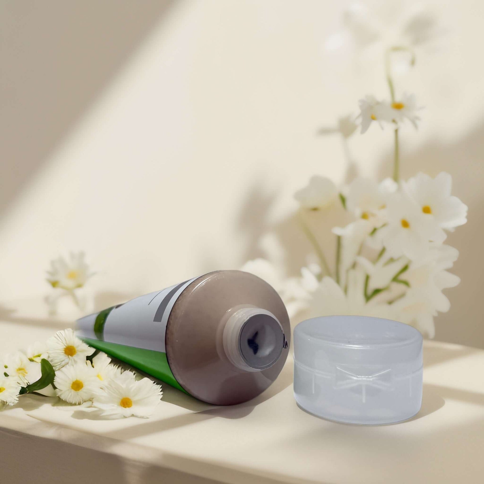Energizing Caffeine & Mint facial scrub tube with flowers.