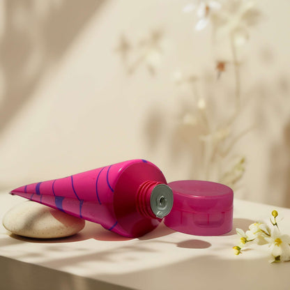 Glittering Nights Body Butter in vibrant pink tube with cap.