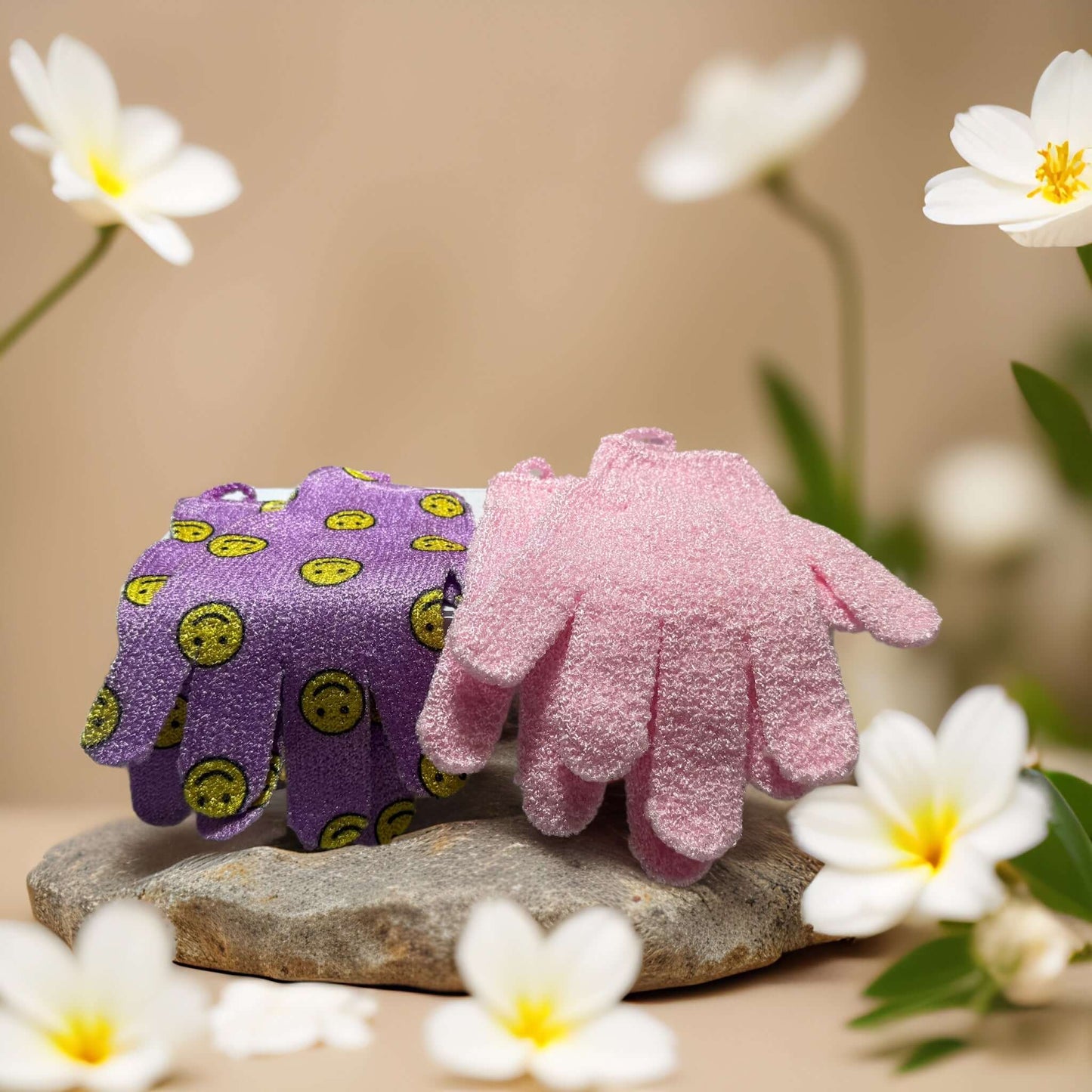 Glow On exfoliating gloves in purple and pink, floral backdrop, perfect for buffing skin and adding cheer to your shower.