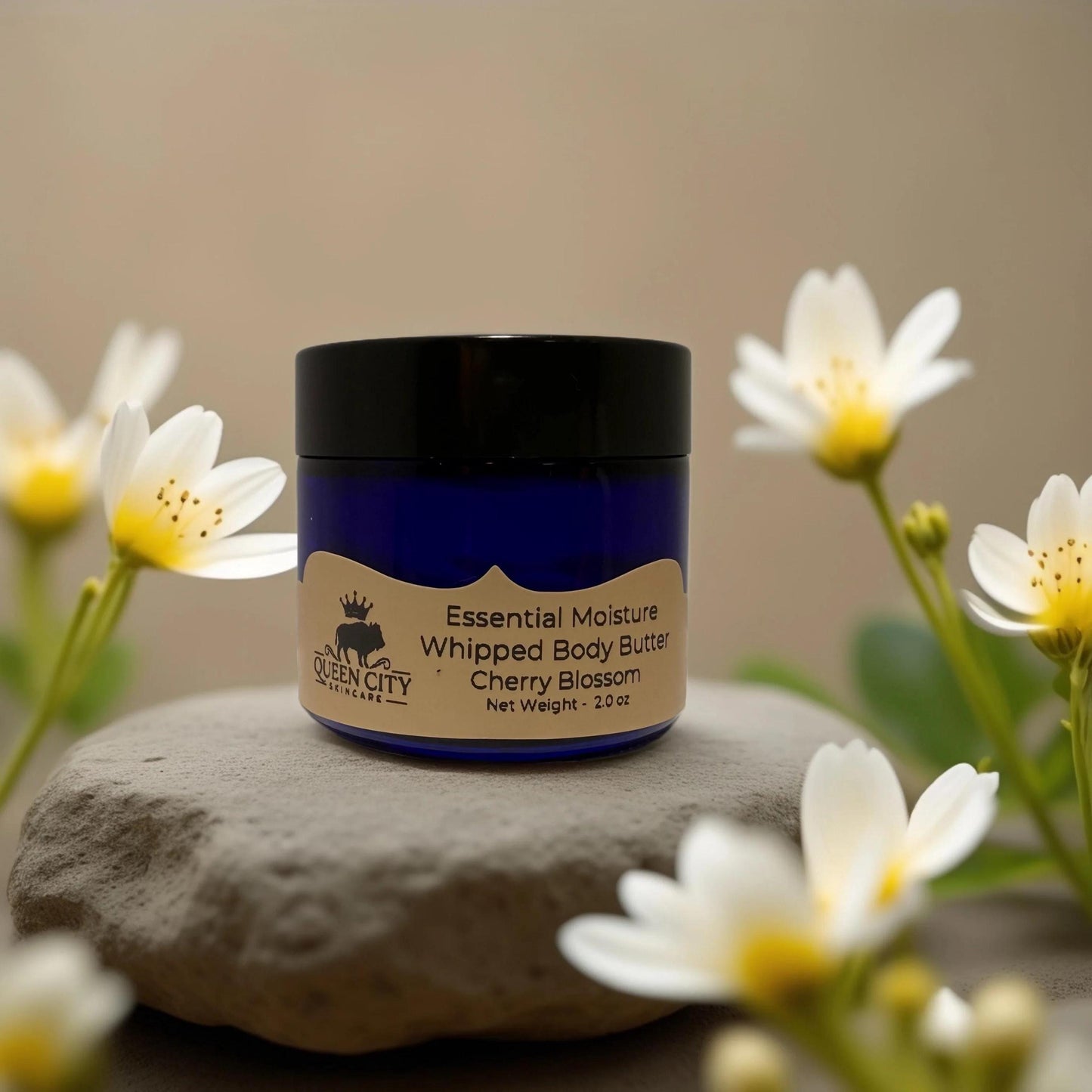 Essential Moisture Whipped Body Butter Cherry Blossom from Queen City Skincare in a floral setting.