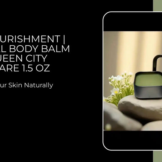 Deep Nourishment Botanical Body Balm by Queen City Skincare on rocks, showcasing natural skin nourishment in 1.5 oz packaging.